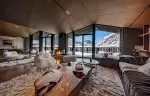 Spacious living room with panoramic windows and mountain views in chalet Cristal.