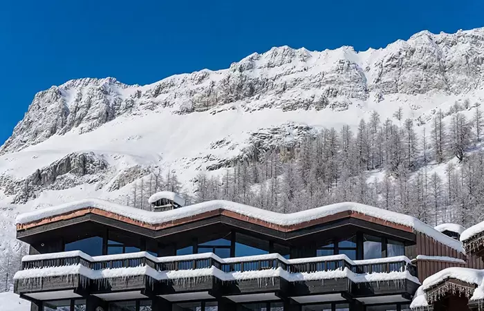 Roof of chalet Cristal against snowy mountains.