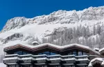 Roof of chalet Cristal against snowy mountains.