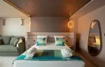 Room with king-size bed and green sofa at Fahrenheit Seven Les Menuires