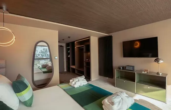Room with open dressing area, TV and full-length mirror at Fahrenheit Seven Les Menuires