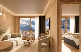 Suite with a bed, armchairs and a window onto the mountains at Barma Hotel & Spa, La Tania