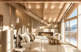 Master Suite bedroom with a fireplace and a wide window onto the peaks at Barma, La Tania