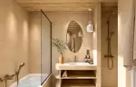 Bathroom with a bathtub, a walk-in shower and an oval mirror at Barma Hotel & Spa, La Tania