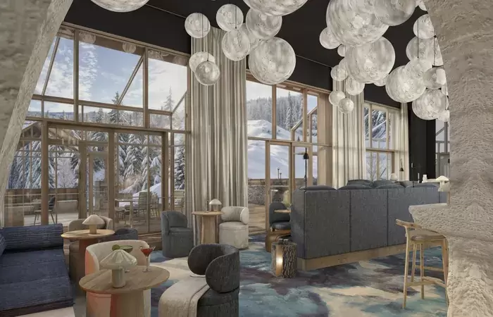 Lounge with armchairs by tall windows onto the forest at Barma Hotel & Spa, Courchevel La Tania