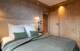 Bedroom with a balcony onto the mountains in an Exception Apartment at Barma Residence, Courchevel La Tania