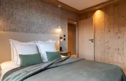 Bathroom in grey tiles with a bathtub, shower and oval mirror in a Signature Apartment, Barma Residence