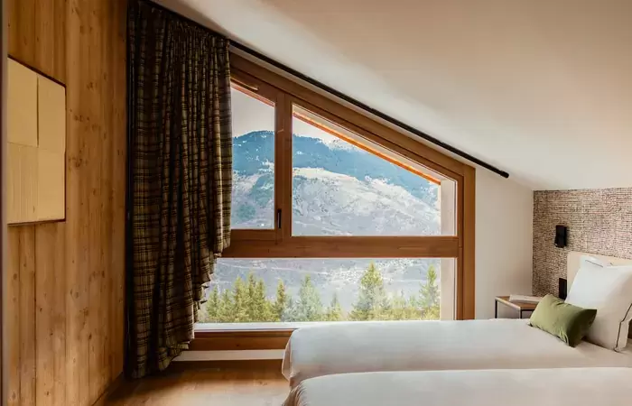Bedroom under a sloping ceiling with a wide window onto the forest, Barma Residence La Tania