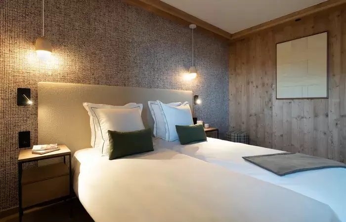 Bedroom with two single beds and a wood-panelled wall at Barma Residence, Courchevel La Tania