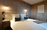 Bedroom with two single beds and a wood-panelled wall at Barma Residence, Courchevel La Tania