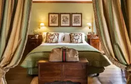 The bedroom of a Prestige Suite with draped curtains at Hotel Hermitage, Breuil-Cervinia