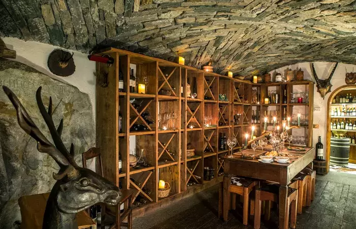 The vaulted stone wine cellar with a stag sculpture at Hotel Hermitage, Breuil-Cervinia