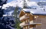 The chalet seen between snow-covered fir trees at No. 14 Verbier