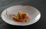 A plated fish starter garnished with fresh herbs at No. 14 Verbier