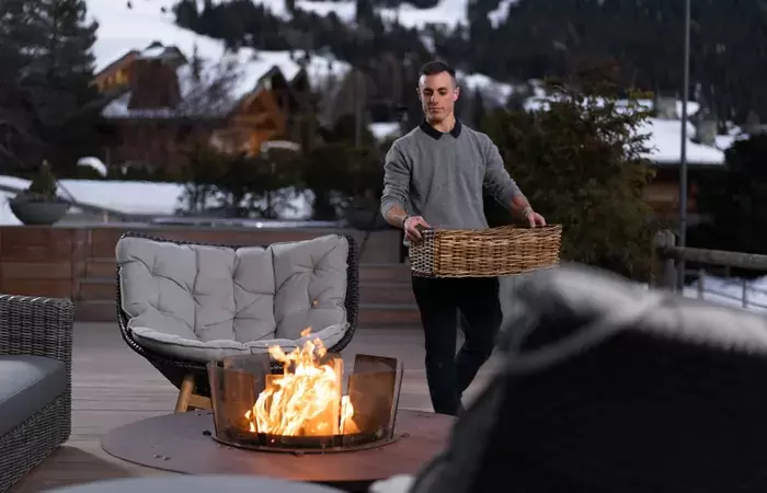 The terrace with a lit fire pit and lounge chairs at No. 14 Verbier